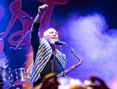 The Black Sorrows live band image on stage with purple lights and smoke effects.